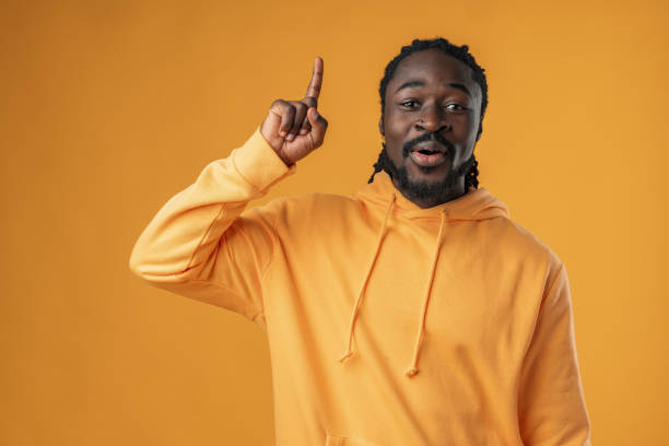 istock African man with beard pointing to copy space against yellow background 1470096041