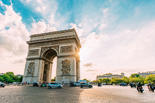 Cars and Motorbikes Driving on the Pl. Charles de Gaulle Traffic Circle around Arc De Triomphe in Downtown Paris on a Sunny Afternoon