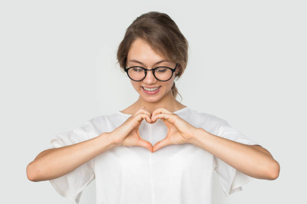 istock Pretty woman confessingg in love, making heart gesture, happy expression, posing over white background. Relationship concept 1470097997