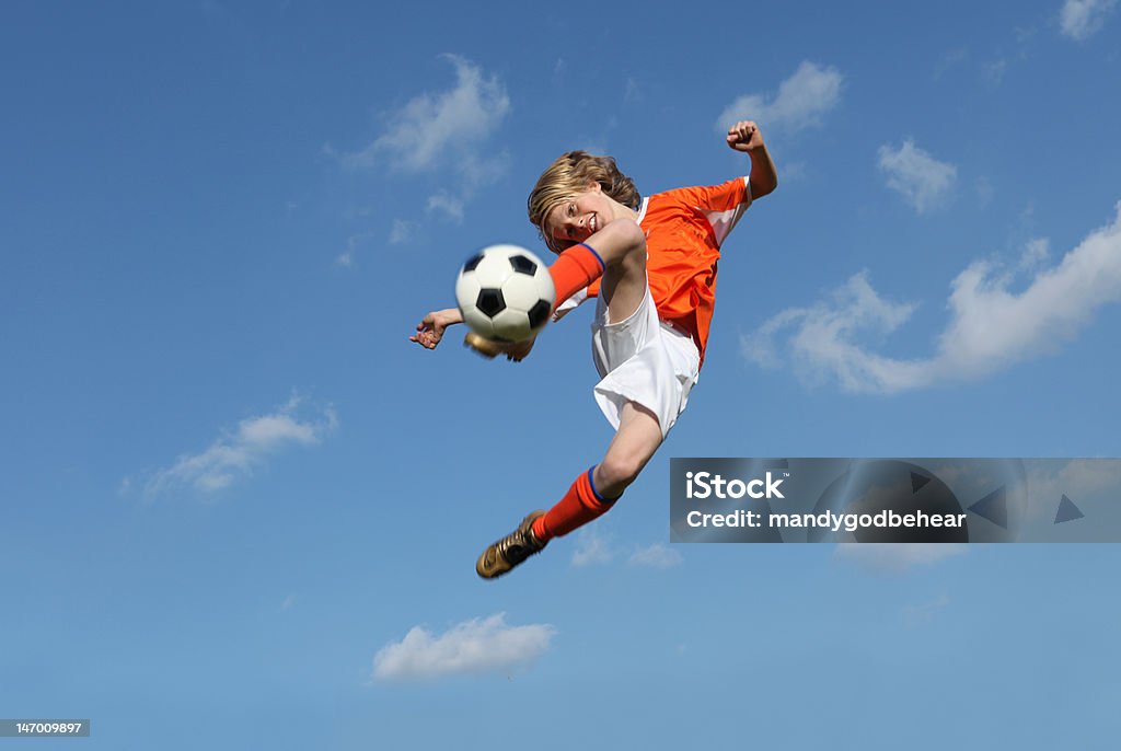 Low angle of boy kicking a soccer ball boy playing football or soccer kicking ball Soccer Stock Photo