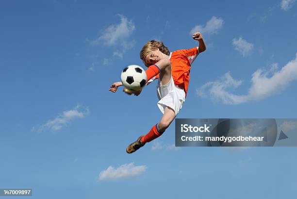 Low Angle Of Boy Kicking A Soccer Ball Stock Photo - Download Image Now - Soccer, Child, Boys