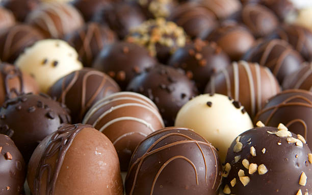 Several chocolate truffles for background image chocolate truffle candy background - focus only on front truffles chocolate truffle stock pictures, royalty-free photos & images