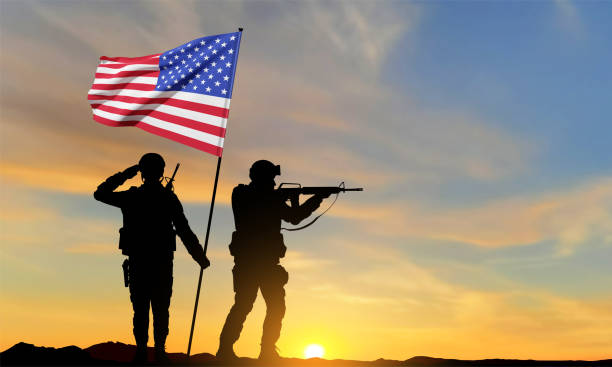 istock Silhouettes of soldiers with USA flag 1470113123
