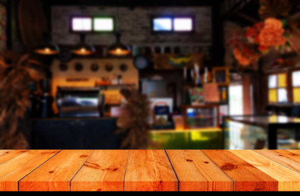 perspective wooden board over blurred cafe counter in coffee shop