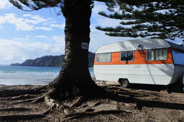 An old caravan camping on beautiful empty beach in New Zealand
