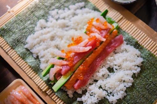 Close-up Shot of Salmon Sashimi Rice Bowl with slice of cucumber, pickled ginger and caviar