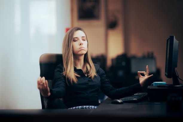 Businesswoman Trying to relax Feeling Zen at the Office stock photo
