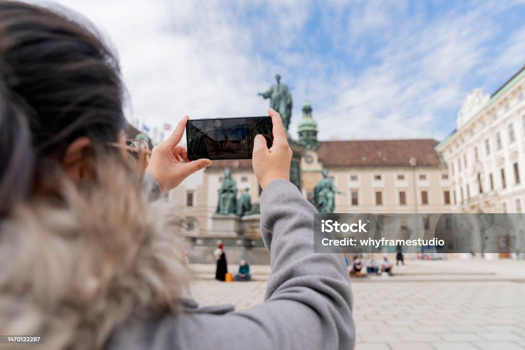 asian female woman traveller enjoy holiday vacation city walking hand using smartphone taking photo of Statue of francis ii Vienna City Hall  in the Historic City Center tour in Vienna Austria 40-44 Years Stock Photo