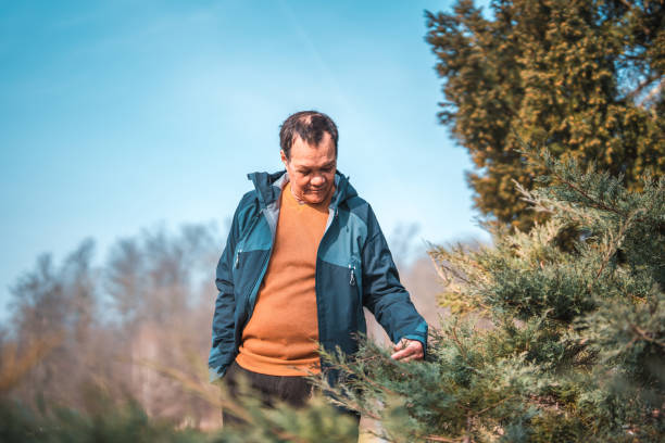 istock Senior Asian Male Touching Plants While Walking In A Public Park 1470122362