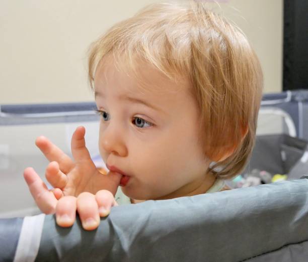 niña de ojos azules chupándose el pulgar - finger in mouth fotografías e imágenes de stock