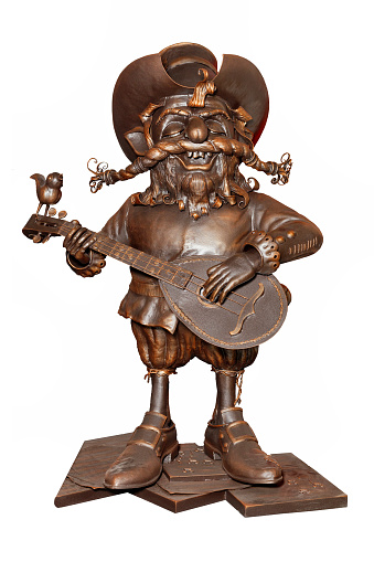 Bronze figurine of a cheerful wandering musician in vintage style playing the guitar, isolated on a white background.