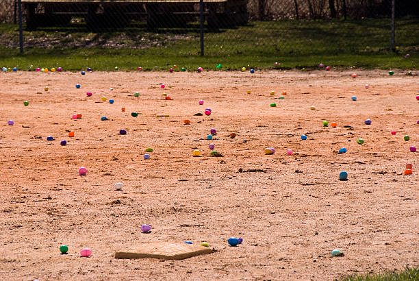 Baseball diamond infield strewn with colorful easter eggs stock photo