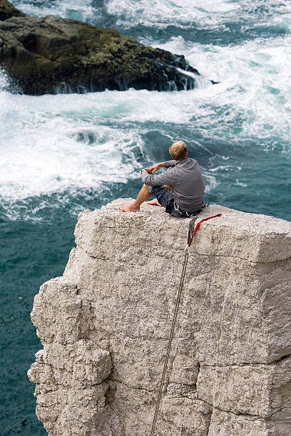 istock Rock climber relaxing and watching sea waves 147012603