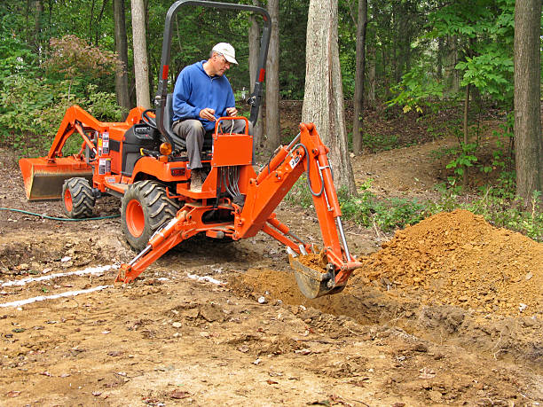 Homem Cavar Trincheira com backhoe - fotografia de stock