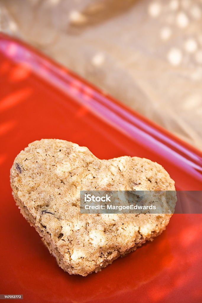 Heart shaped cookie Concept of healthy food is good for your heart oatmeal raisin cookie on red plate Baked Stock Photo