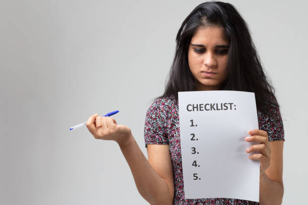 istock Indian young woman analyzes checklist 1470128434