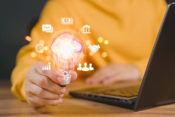 istock Man holding a light bulb while working on the computer to think and create new ideas. Business global internet connection application technology and digital marketing, Financial and banking. 1470130915