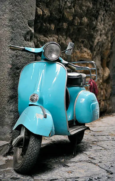 Classic italian Vespa scooter parked in an italian cobbled street.