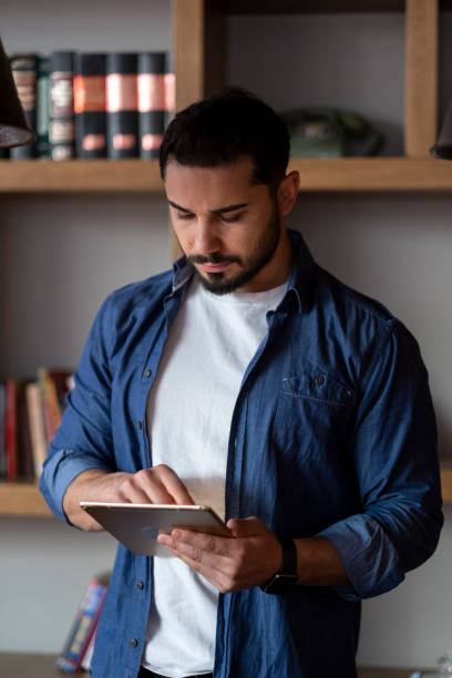 istock handsome young man surfing internet on tablet 1470133994