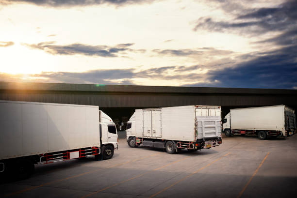 istock Cargo Container Trucks on Parking at Distribution Warehouse. Lifting Ramp Trucks. Commercial Truck Transport Lorry. Shipping Delivery Trucks. Freight Truck Logistics Cargo Transport 1470134873