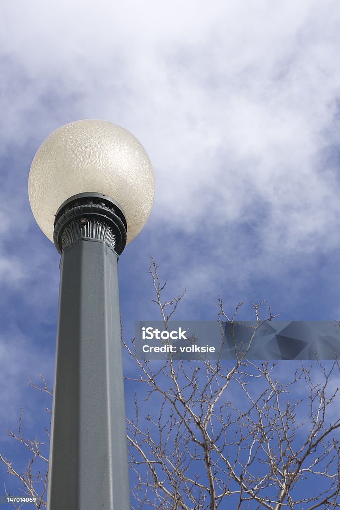 Street Lamp and Blue Sky This is a white globed street lamp with a blue sky as background Blue Stock Photo