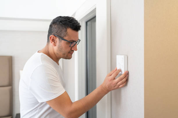 The Man Who Adjusts The Room Temperature From The Air Conditioning Panel Man Setting Temperature On Air Conditioner Control Panel In Hotel Room fahrenheit stock pictures, royalty-free photos & images