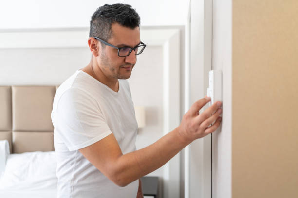 istock The Man Who Adjusts The Room Temperature From The Air Conditioning Panel 1470140923