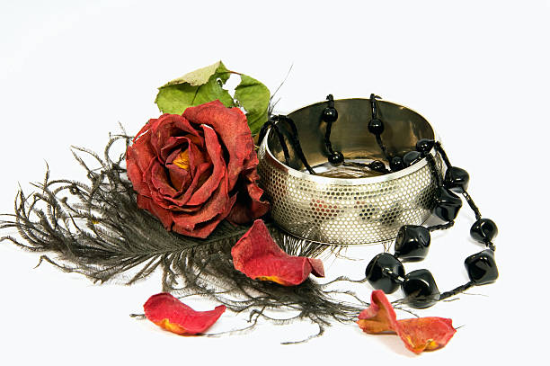 Close-up of a woman's diamond jewelry in red rose flowers on a black background.