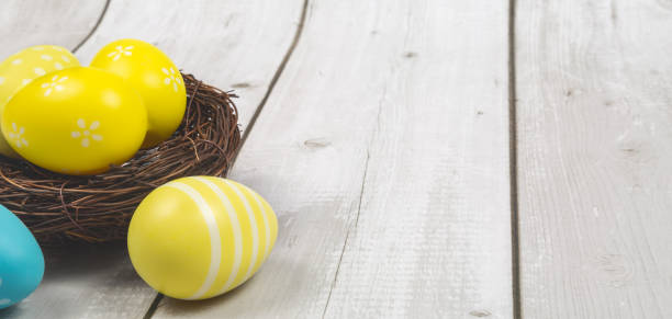 istock Easter background with colored eggs in nest on white wooden background with copy space 1470141233