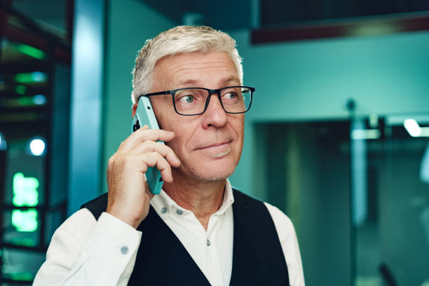 istock Handsome mature businessman talking on mobile phone in the office 1470141407