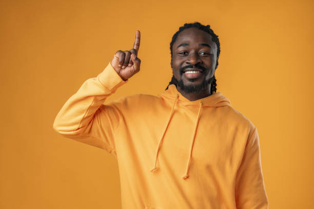 istock African man with beard pointing to copy space against yellow background 1470142283
