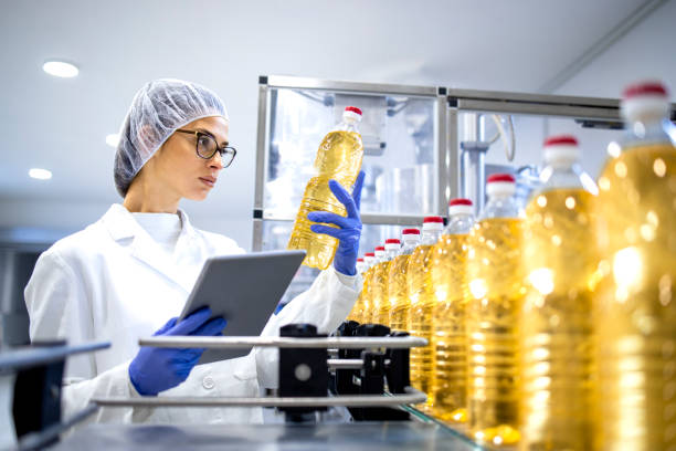 istock Food inspector or technologist doing quality control of bottled vegetable oil inside bottling plant. 1470143926
