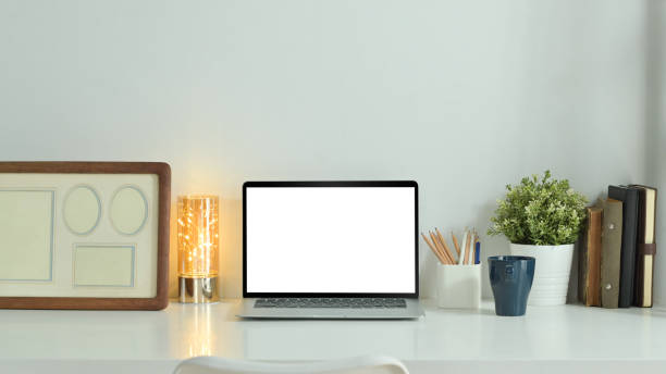 istock Home office desk with laptop computer, coffee cup, potted plant and picture frame. Empty screen for graphic display montage. 1470144259