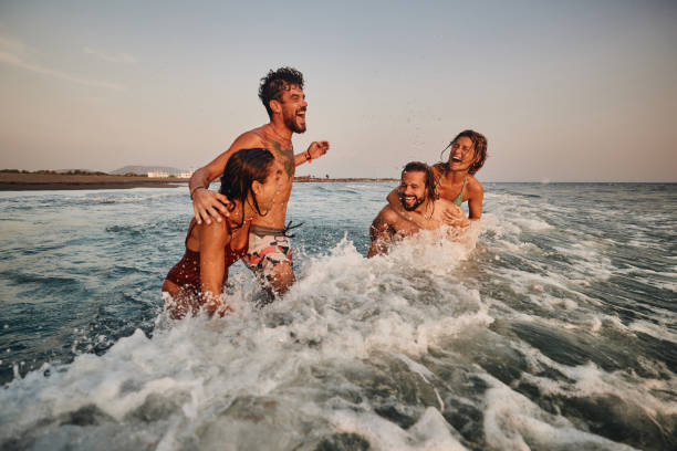 istock Young cheerful couples having fun during summer vacation in sea. 1470145261