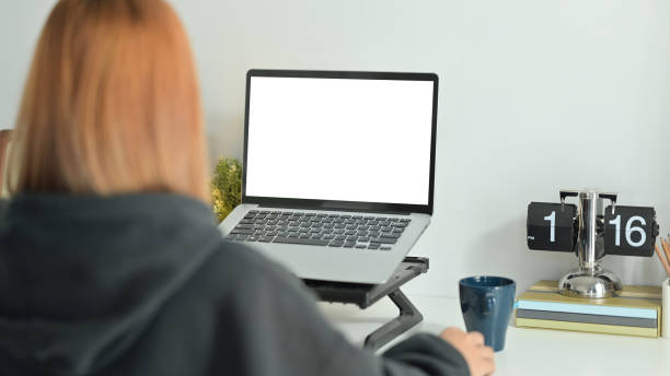 istock Back view of creative female freelancer sitting in comfortable workplace and working online with laptop computer. 1470145744