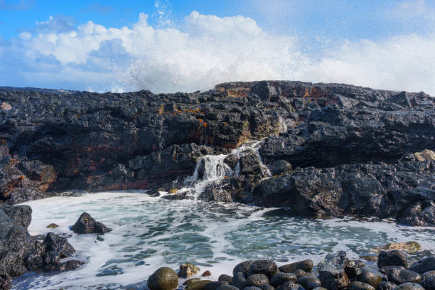 istock Volcanic Rocks on Hawaiian Coastline with Ocean Wave 1470146377