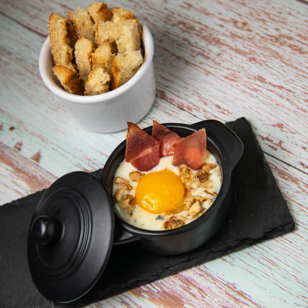 istock Recipe Oeuf cocotte with fresh cream sauce, Roquefort and walnuts, ham chips, toasted bread sticks 1470146885