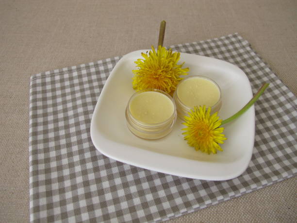 Homemade dandelion ointment, salve with an oil extract of dandelion flowers stock photo