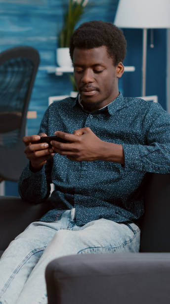 istock Exhausted african american man falling asleep while holding phone in his hands 1470155255