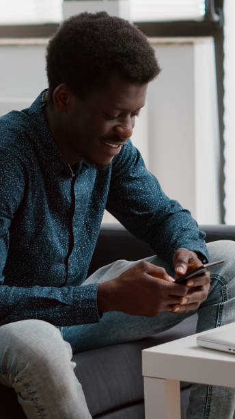 istock Positive authentic black african american man smiling while using a smartphone 1470155325