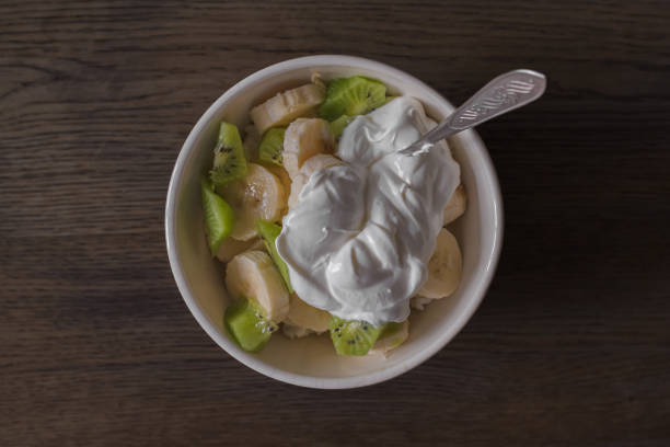Nutritious breakfast. Curd dessert. Fruit salad. Fruit in sour cream. Pieces of kiwi and banana with yogurt. Healthy breakfast.