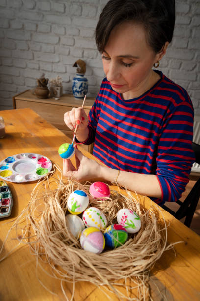 istock Woman painting Easter Egg and preparing for Easter holiday celebration 1470156734