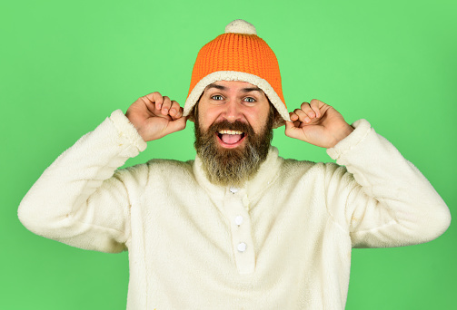 Feeling good. Bearded hipster. Hipster style. Head in warm hat. Handsome man knitted hat with pom pom. Fashion concept. Winter clothes and accessories. Mature emotional hipster funny style accessory.