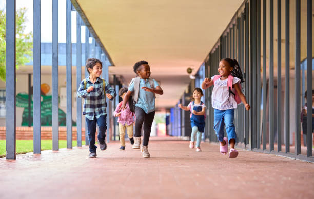 istock Group Of Multi-Cultural Elementary School Pupils Running Along Walkway Outdoors At School 1470158904
