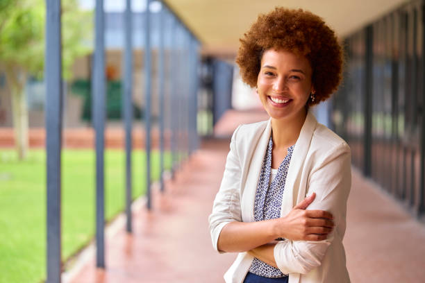 Portrait Of Smiling Female Elementary School Teacher Outdoors At School Portrait Of Smiling Female Elementary School Teacher Outdoors At School teachers stock pictures, royalty-free photos & images