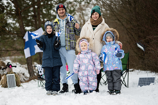 Finnish family with Finland flags on a nice winter day. Nordic Scandinavian people.