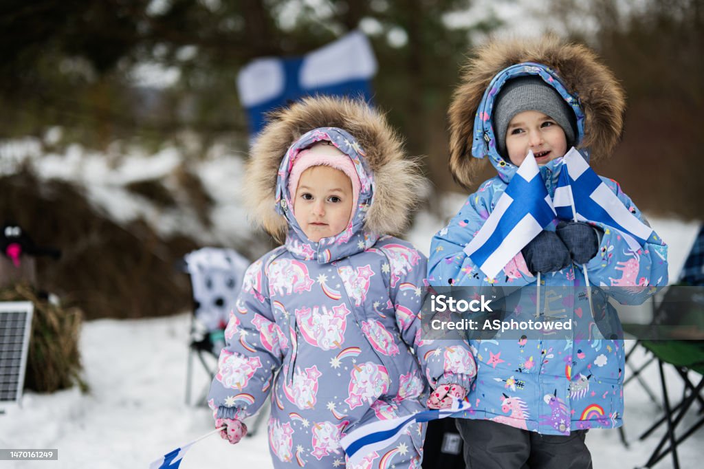 Two finnish sisters with Finland flags on a nice winter day. Nordic Scandinavian people. Helsinki Stock Photo