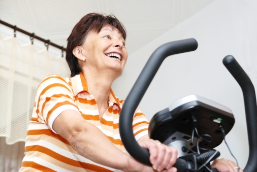 Senior woman exercise on exercising bicycle at home