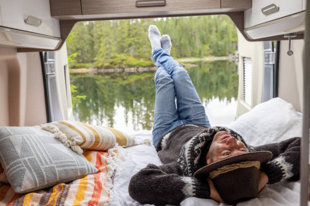 istock Man lying on bed at the back of a van, van life concept 1470161895