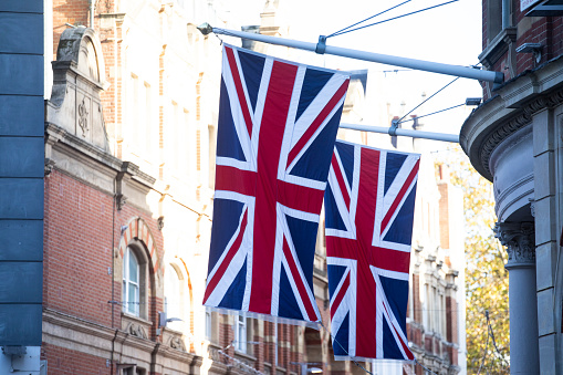 Royalty free stock photo of 3 Union Jack flags hanging above Regent's street in London.See
